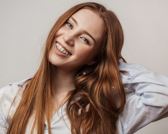 Teen with braces smiles