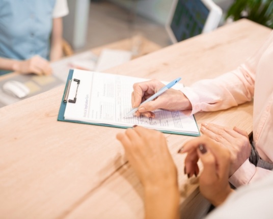 Dentistry patient filling out dental insurance forms