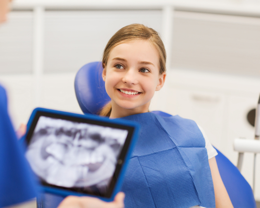 Dentist looking at digital x-rays during emergency kids dentistry visit
