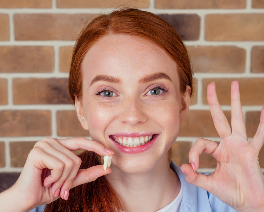 Young woman smiling after wisdom tooth extractions