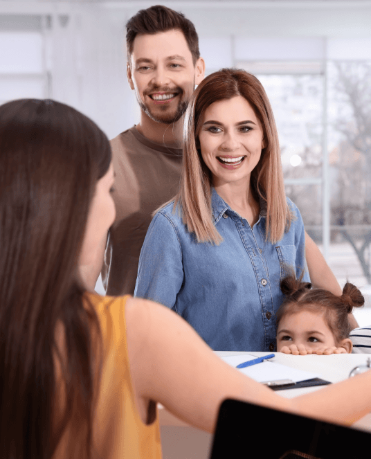 Parents and child turning in dental insurance forms