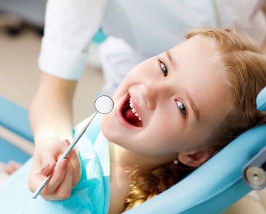 Child receiving dental checkup and teeth cleaning