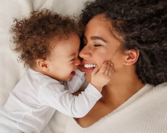 Mother and baby smiling together after laser frenectomy treatment