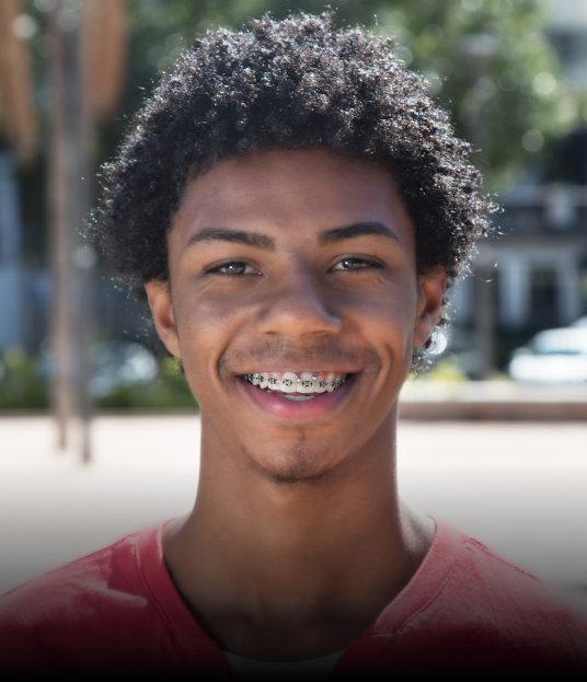 Teen with traditional braces orthodontics on teeth