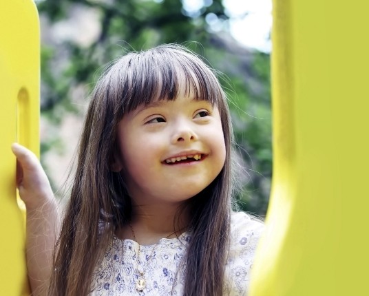 Child with special needs smiling outdoors