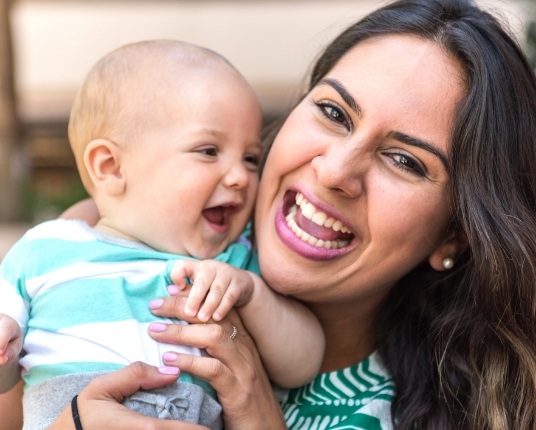 Mother holding baby after dentistry for infants visit