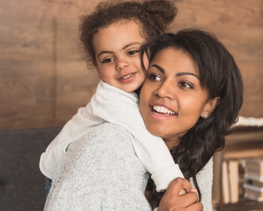 Mother holding child during dentistry for children appointment