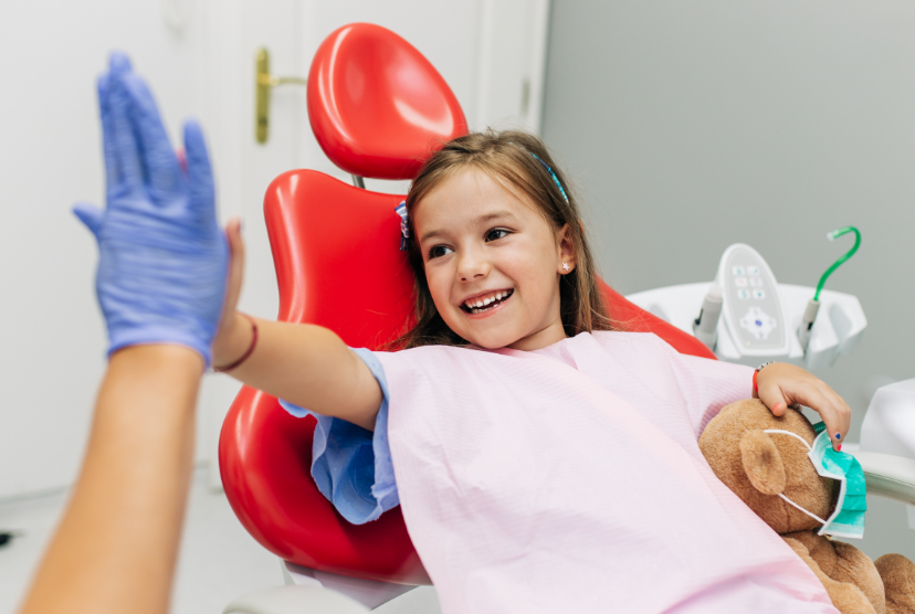Child high fiving dentist at appointment